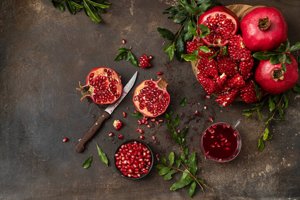 Ripe pomegranate with leaves  on a dark background - Photo, Image