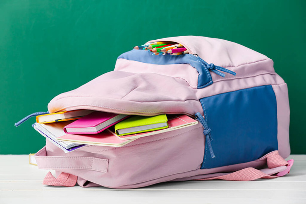Κομψή σχολική τσάντα πλάτης σε ξύλινο τραπέζι στην τάξη - Φωτογραφία, εικόνα