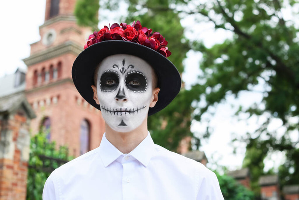 Młody człowiek z pomalowaną czaszką na zewnątrz. Obchody Meksykańskiego Dnia Zmarłych (El Dia de Muertos) - Zdjęcie, obraz
