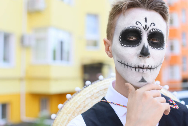 Joven con el cráneo pintado en su cara al aire libre. Celebración del Día de Muertos de México (El Día de Muertos)) - Foto, Imagen