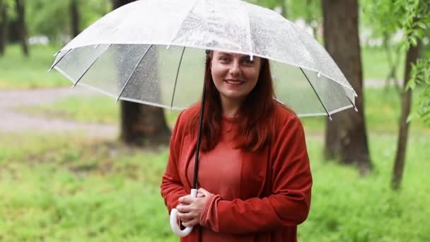 Des gouttes de pluie. Belle femme tenant parapluie transparent dans la journée de pluie - Séquence, vidéo