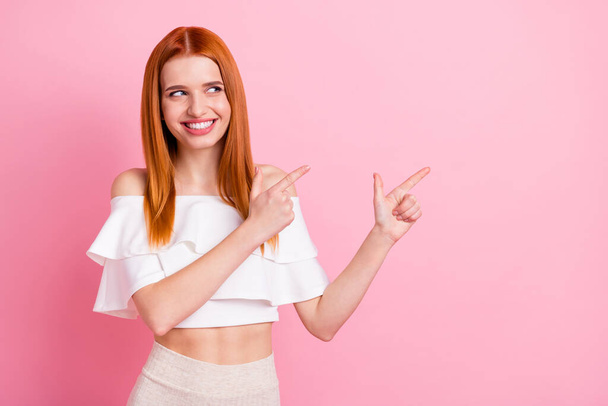 Photo of young happy cheerful woman point finger empty space smile sale isolated on pink color background - Zdjęcie, obraz