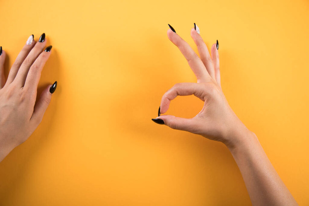female hand shows ok on orange background - Foto, Bild