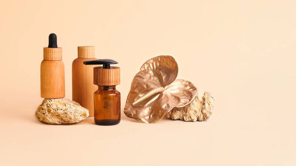 Composition from the natural stones,golden flamingo flower and wooden cosmetics containers.Concept of the organic,zero waste materials.Beautiful beige palette,large banner with copy space. - Photo, Image