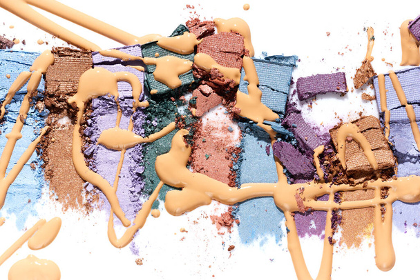 Verschmutzter Lidschatten verschiedene Farben und flüssiges Make-up Foundation isoliert auf weißem Hintergrund - Foto, Bild