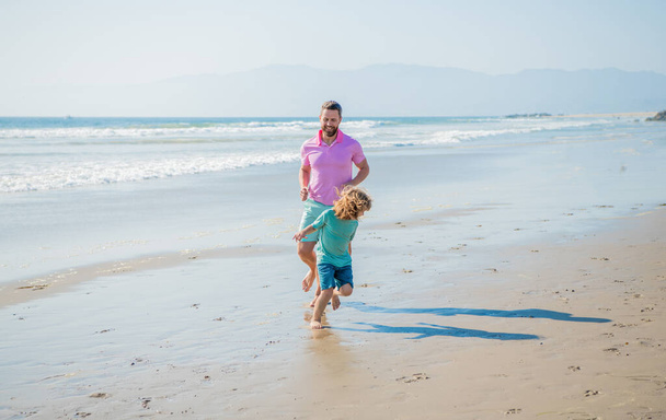 πατέρας και γιος οικογένεια τρέχει στην παραλία του καλοκαιριού, οικογενειακό άθλημα - Φωτογραφία, εικόνα