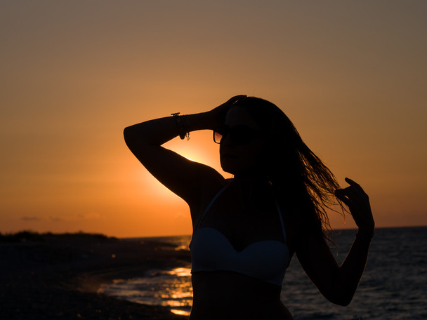 Woman standing at the beach during beautiful sunset. - Foto, Imagem