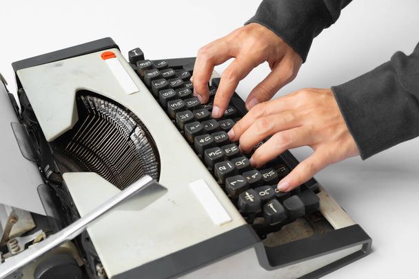 Ludzie wpisują stare tajskie tradycyjne maszyny do pisania. Klasyczny vintage zabytkowe ręczne maszynę do pisania izolowane na białym tle. Pozycja z XIX wieku. Styl życia - Zdjęcie, obraz
