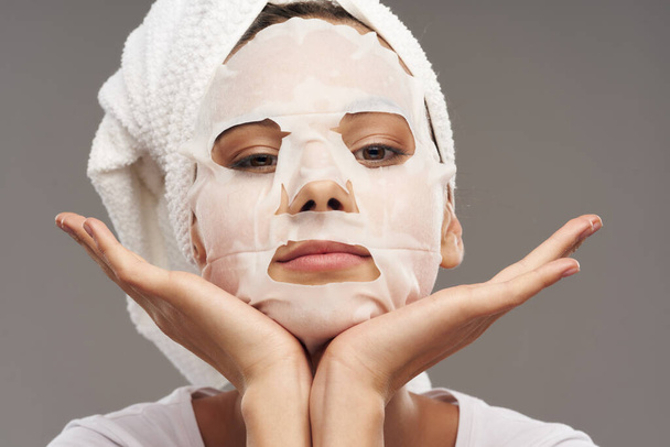 Frau in Maske mit Handtuch auf dem Kopf Hautpflege-Kosmetik - Foto, Bild