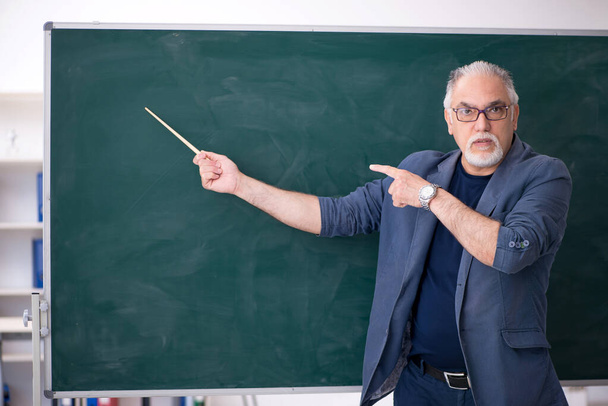 Öreg férfi tanár az osztályteremben. - Fotó, kép