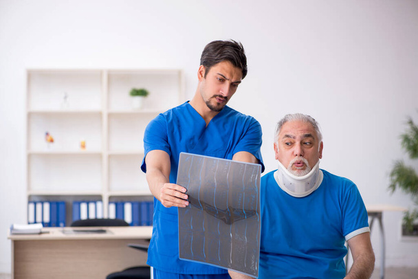 Anciano paciente masculino visitando joven médico radiólogo - Foto, Imagen