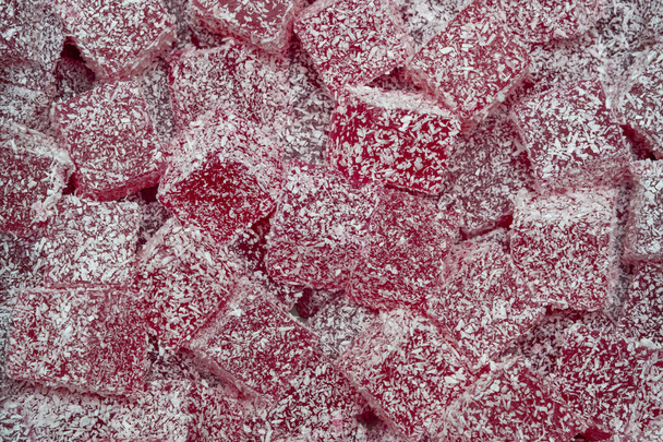 Tło marmolady to czerwony sześcian na pełnym ekranie. Słodycze z cukrem na półce w sklepie. - Zdjęcie, obraz