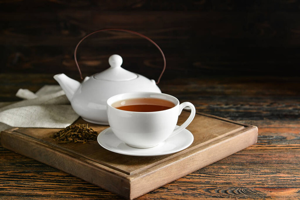 おいしいほうじ茶のカップと木製のボードテーブルの上の緑茶とポット - 写真・画像
