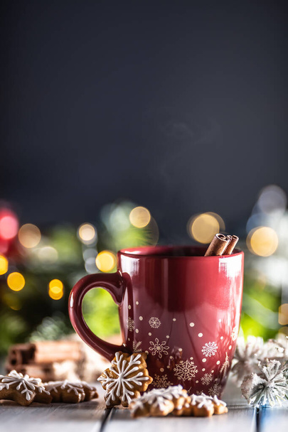 Christmas punch in a red cup with gingerbread cinnamon and holiday decorations. - Fotoğraf, Görsel