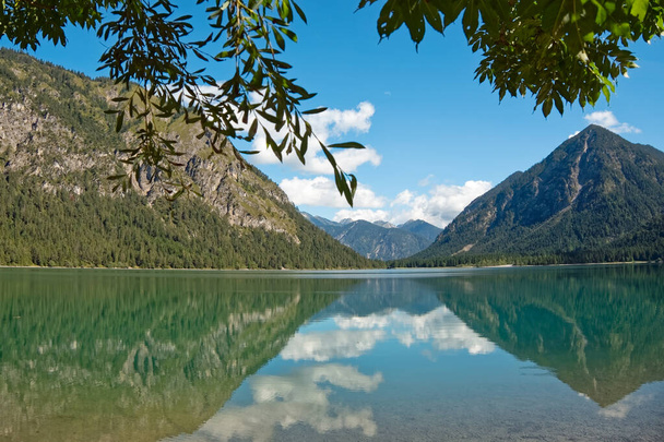 Αλπική λίμνη σε ένα περιβάλλον βουνών και δασών - Φωτογραφία, εικόνα
