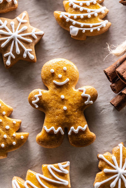 Gingerbread man and other Christmas cookies along with cinnamon. - Фото, зображення