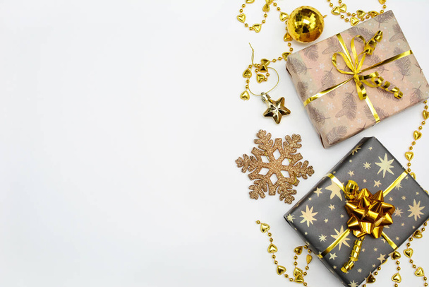 Christmas, New Year. Elegant gift boxes with gold ribbons, stars, beads on a white background. View from above. Copy space. - Photo, Image