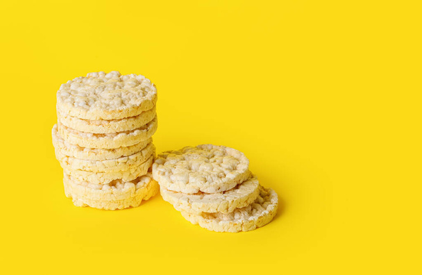 Pila de galletas de arroz infladas sobre fondo amarillo - Foto, Imagen