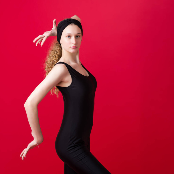 Beautiful slim girl dancer posing in the studio - Фото, изображение