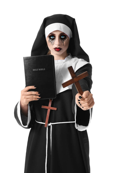 Γυναίκα ντυμένη για το Halloween ως καλόγρια με τη Βίβλο και σταυρό σε λευκό φόντο - Φωτογραφία, εικόνα