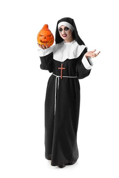 Žena oblečená na Halloween jako jeptiška s dýní na bílém pozadí - Fotografie, Obrázek