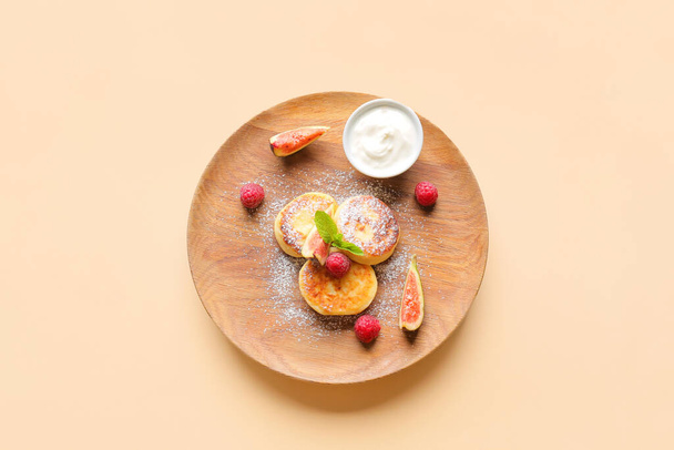 Piatto con pancake di fiocchi di latte e lamponi e frutta su sfondo di colore - Foto, immagini