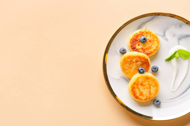 Piatto con pancake di fiocchi di latte e mirtilli su sfondo di colore - Foto, immagini