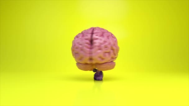 Dansende hersenen op een kleurrijke gele achtergrond. Kunstmatige intelligentie concept. 3d animatie van een naadloze lus - Video
