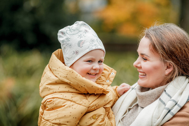 Счастливая мама и маленькая дочь в осеннем парке. Яркие осенние цвета. Падение. - Фото, изображение