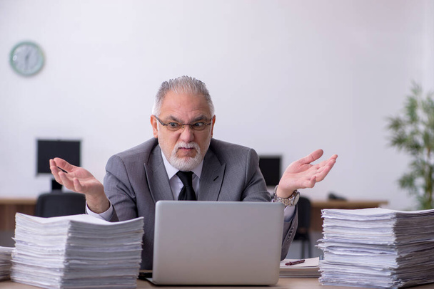 Stary mężczyzna pracownik niezadowolony z nadmiernej pracy w biurze - Zdjęcie, obraz