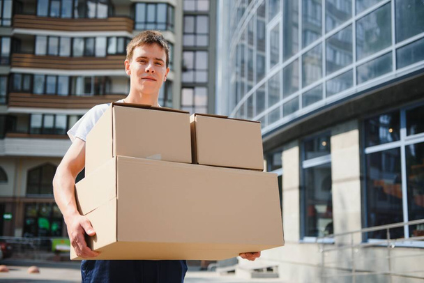 Smiling delivery man holding a paper box - Foto, Imagem