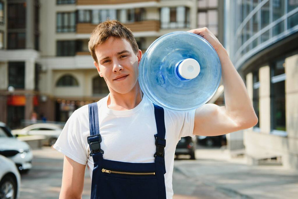 Delivery man with bottle of water outdoors - 写真・画像