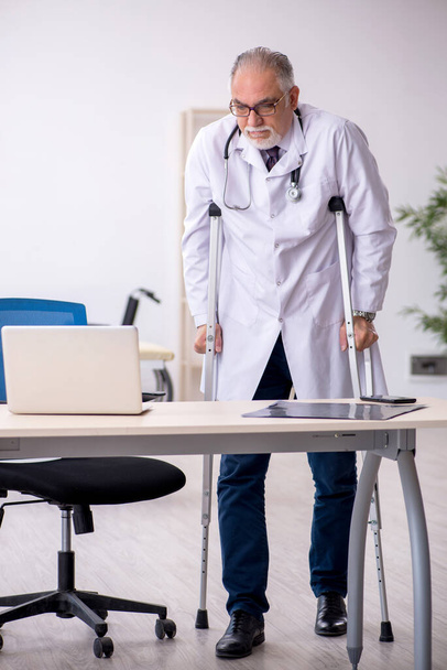 Láb sérült öreg férfi orvos dolgozik a klinikán - Fotó, kép