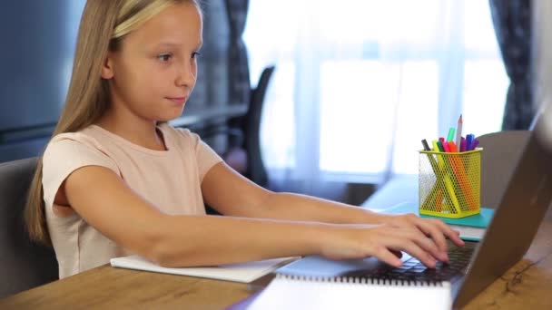 Schulmädchen lernen online mit einem modernen Laptop. Hausaufgaben - Filmmaterial, Video