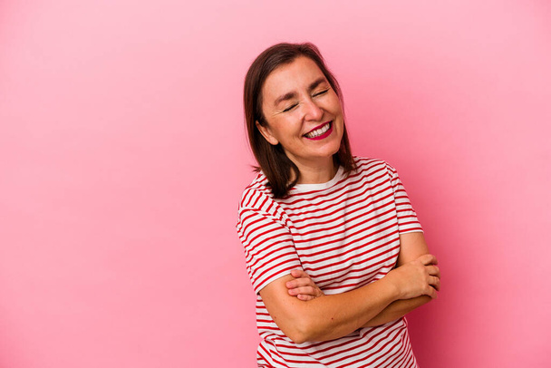 Middle age caucasian woman isolated on pink background smiling confident with crossed arms. - Foto, afbeelding
