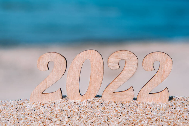 New Year's numbers 2022 on the beach by the sea. Tourism, recreation and travel concept. Creative Christmas card. Copy space. Selective focus. - Photo, Image
