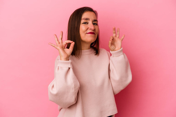 Middle age caucasian woman isolated on pink background cheerful and confident showing ok gesture. - Photo, Image