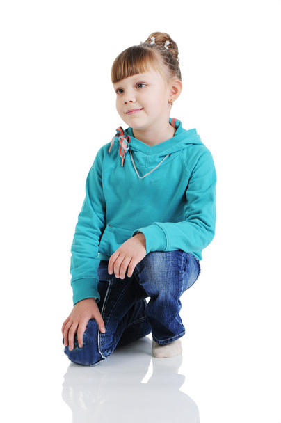 Charming little girl seated in a model pose. Isolated on the whi - Фото, зображення