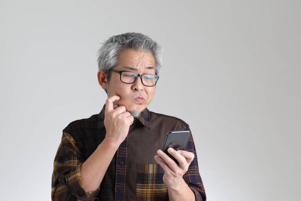 Der ältere asiatische Mann auf weißem Hintergrund - Foto, Bild