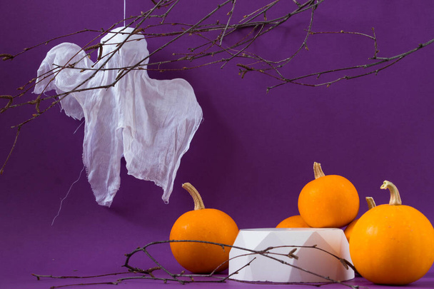 Концепция праздника Хэллоуина. Подиумы или пьедесталы для демонстрации продуктов, белых призраков и осенних тыкв на фиолетовом фоне. - Фото, изображение