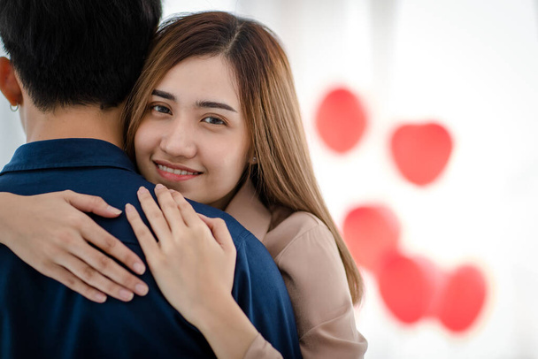 Joyeux jeune asiatique souriant avec des yeux heureux et embrassant petit ami pendant la date de la Saint-Valentin. Véritable amour et relation des amants des adolescents concept. - Photo, image