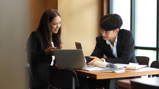 Двое коллег счастливы работать вместе, деловая женщина и бизнесмен обсуждают работу в офисе. рабочие отношения - Фото, изображение
