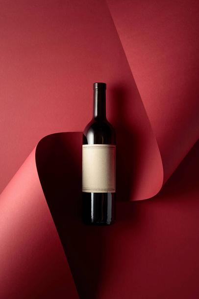 Láhev červeného vína se starou prázdnou etiketou a modrými hrozny. Kopírovat místo pro text, horní pohled. - Fotografie, Obrázek