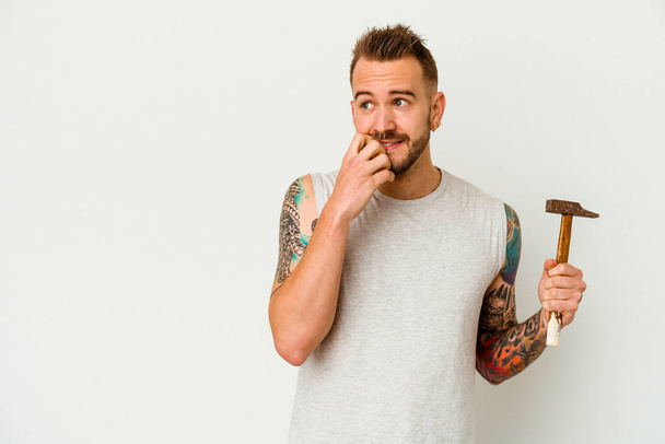 Young tattooed caucasian man isolated on white background relaxed thinking about something looking at a copy space. - Photo, image