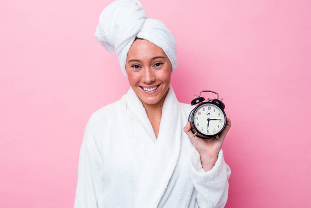 Young australian woman leaving the shower late isolated on pink background happy, smiling and cheerful. - Fotografie, Obrázek