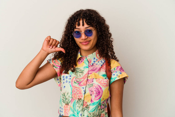 Giovane donna di razza mista che indossa occhiali da sole prendendo una vacanza isolata mostrando un gesto antipatico, pollici verso il basso. Concetto di disaccordo. - Foto, immagini
