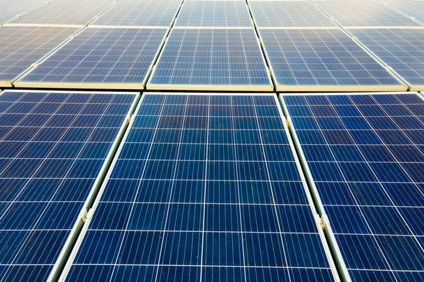 Primer plano de la superficie de los paneles solares fotovoltaicos azules montados en el techo del edificio para producir electricidad ecológica limpia. Concepto de producción de energías renovables. - Foto, Imagen