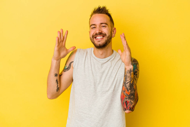 Jeune homme caucasien tatoué isolé sur fond jaune joyeux rire beaucoup. Concept de bonheur. - Photo, image