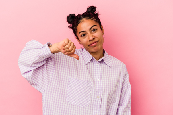 Young latin woman isolated on pink background showing a dislike gesture, thumbs down. Disagreement concept. - Photo, Image