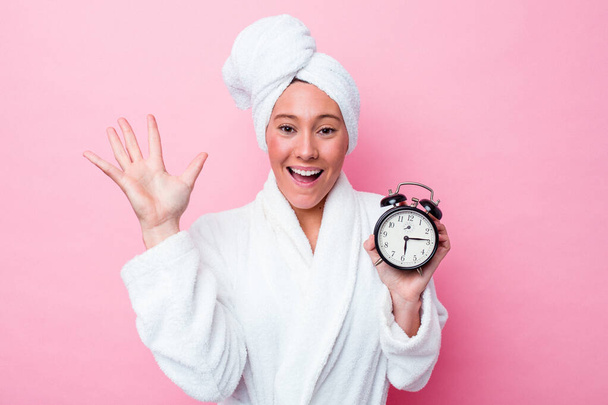 Young australian woman leaving the shower late isolated on pink background receiving a pleasant surprise, excited and raising hands. - Φωτογραφία, εικόνα